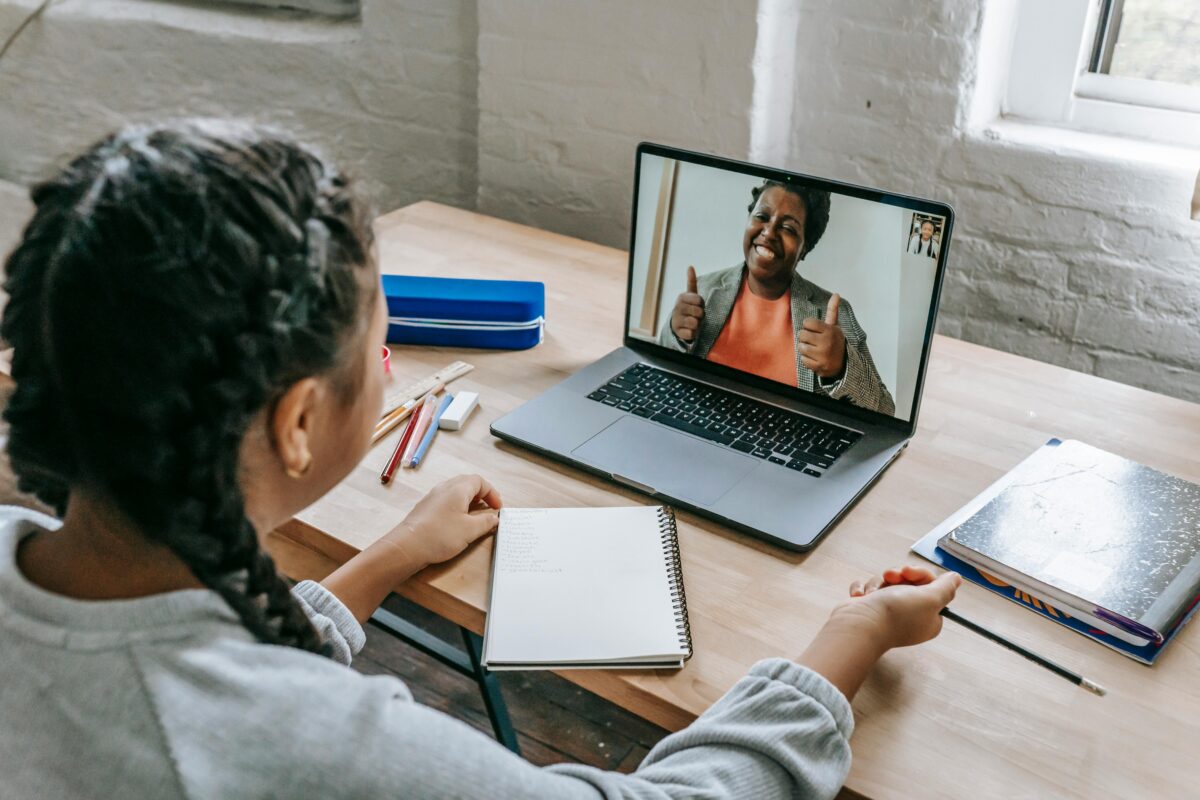 A young student connecting with a teacher via video call for an online lesson.